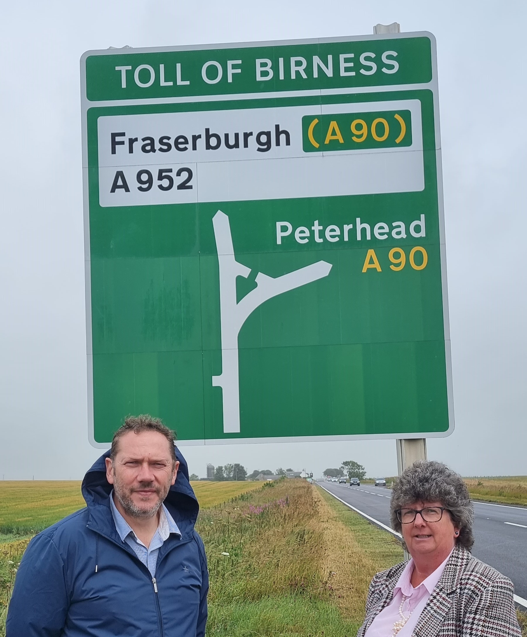 Douglas Lumsden MSP standing alongside Cllr Gillian Owen beside the A90