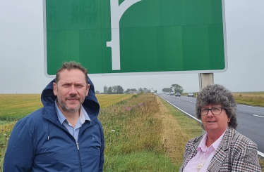 Douglas Lumsden MSP standing alongside Cllr Gillian Owen beside the A90