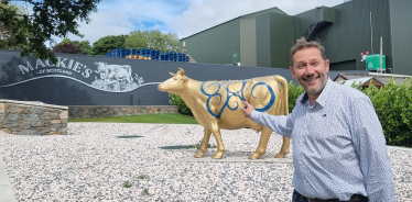 Douglas outside Mackie's of Scotland in front of their golden cow statue